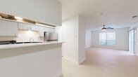 Located in Mesquite, TX, this well-designed single-story unit offers a clean, modern aesthetic with a bright and airy atmosphere. The open-concept living and dining area serves as the heart of the home, finished with light wood-style flooring that extends throughout the unit. Ceiling fans are installed in the main living space, providing comfort and contributing to the room's clean look. A sliding glass door in the living area brings in natural light and provides outdoor access. The kitchen features gray cabinetry, white subway tile backsplash, light countertops, a stainless steel refrigerator, and a deep double-basin sink, all laid out for efficient use. A pass-through counter connects the kitchen to the living and dining area, enhancing the open feel of the space. The bedroom is generously proportioned, with a ceiling fan, a large window with blinds allowing ample natural light, and direct access to multiple closets for storage. A dedicated laundry area and a pantry add everyday convenience. The bathroom is neatly appointed, and a hallway connects the private areas of the unit. Throughout, white walls and consistent flooring create a cohesive, move-in-ready environment well-suited for comfortable living.