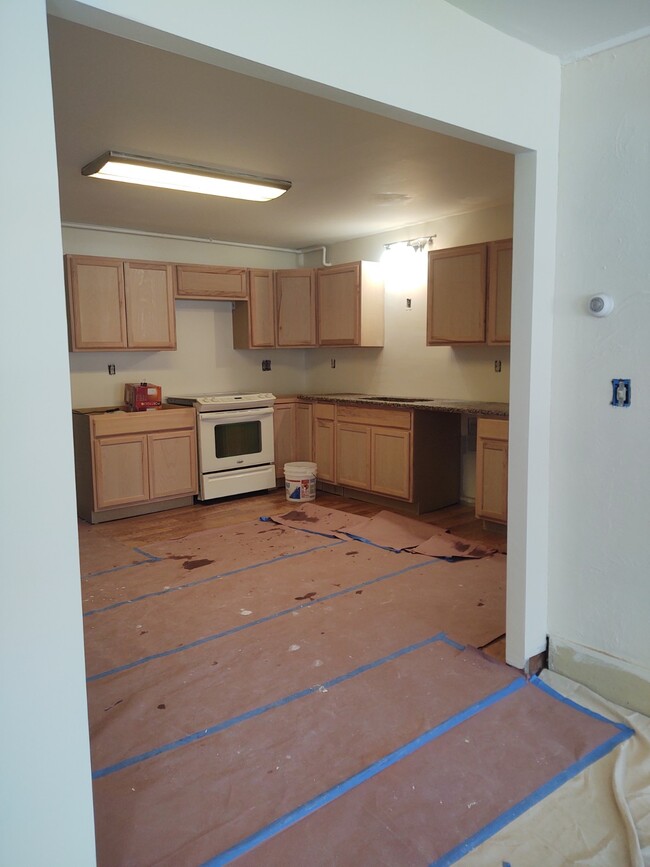 Kitchen from living room, Pre completed appliance install. Floors are covered to protect - 419 Marlboro St