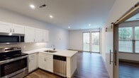 Located at 375 Terrace Ave in Cincinnati, Ohio, this single-floor unit offers a thoughtfully designed, contemporary living space with modern finishes throughout. The open-concept layout connects the kitchen directly to the living area, creating a cohesive and functional flow. Large sliding glass doors at the end of the living space invite natural light and provide views of the outdoors, enhancing the overall sense of openness.

The kitchen is a standout feature, outfitted with crisp white shaker-style cabinetry, marble-look quartz countertops, and a classic subway tile backsplash. Stainless steel appliances — including a refrigerator, range, microwave, and dishwasher — complement the clean aesthetic. The peninsula-style counter extends the workspace and doubles as a casual dining or gathering area.

Wood-look plank flooring runs throughout the main living and bedroom areas, adding warmth and visual continuity. The bedroom is comfortably sized, fitted with a ceiling fan and natural light from a window, along with access to a closet.

The bathroom features a classic black-and-white mosaic tile floor, a glass-enclosed walk-in shower with white subway tile surround, a generous vanity with a wide mirror, and ample under-sink storage. Recessed lighting throughout the unit contributes to a bright, polished atmosphere.