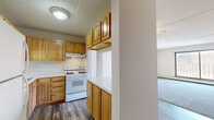 Located at 460 Fifth Ave N in Hopkins, MN, this single-floor residence offers a practical and comfortable layout with one bedroom, three bathrooms, and a well-organized floor plan. The kitchen and dining area are combined into one functional space, featuring warm honey-toned wood cabinetry, white appliances including a gas range and dishwasher, a double sink, light countertops, and durable hardwood-style flooring. A pass-through counter opens the kitchen toward the entry, enhancing the sense of openness and flow. The living room is generously proportioned, finished with plush carpeting, baseboard heating, and a large sliding glass door that opens to a private balcony, allowing natural light to fill the space. The primary bedroom is a comfortable size, also carpeted, with a window providing natural light and access to ample closet storage — four closets are distributed throughout the unit. The three bathrooms include tiled flooring and functional fixtures, with one featuring mosaic tile detailing. Two hallways connect the spaces efficiently. The textured ceilings and neutral wall tones create a clean, understated aesthetic throughout, making this residence a practical and move-in-ready home in the heart of Hopkins.