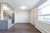 Located at 1470 Williamsport Dr in Mississauga, Ontario, this one-bedroom, one-bathroom unit offers a comfortable and efficiently designed layout across a single floor. Wood-look laminate flooring flows throughout the living areas, adding warmth and continuity to the space.

The combined kitchen and living area forms the heart of the unit. The kitchen is well-appointed with modern taupe cabinetry, a granite-topped island, a tiled backsplash, and stainless steel appliances including a refrigerator, stove, and dishwasher. Track lighting above the kitchen enhances functionality. The adjacent living area is bright and open, featuring large windows with a baseboard heating unit beneath, allowing natural light to fill the room while offering views of the surrounding neighbourhood.

The bedroom is a comfortable size, equipped with mirrored sliding closet doors and a large window that frames tree-lined and neighbourhood views, keeping the room airy and well-lit. A baseboard heater ensures year-round comfort.

The bathroom features a clean, classic design with large beige marble-style wall tiles surrounding a full soaker tub and shower combination, complemented by chrome fixtures. The overall aesthetic of the unit is neutral and move-in ready, offering a functional and inviting living environment.
