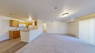 Located at 368 S Mall Dr in St. George, Utah, this single-floor unit offers four bedrooms, two bathrooms, and a well-considered layout designed for comfortable everyday living. The open-concept living area is spacious and bright, with plush carpeting underfoot and flush ceiling lighting. It flows seamlessly into the kitchen, which is separated by a half-wall breakfast bar. The galley-style kitchen features warm wood-toned cabinetry lining both walls, light wood-look flooring, a gas range, dishwasher, and ample counter space, making it both functional and efficient. The generously sized primary bedroom includes a sliding glass door with vertical blinds that lets in natural light and provides outdoor access. The remaining bedrooms are well-proportioned, carpeted, and each equipped with windows fitted with horizontal blinds for light control and privacy. Both bathrooms are clean and functional, with one featuring a full tub-shower combo with white tile surround and wood-look flooring. A dedicated laundry room includes washer and dryer hookups — both electric and gas — plus overhead wire shelving for added storage. Two hallways connect the living spaces to the bedrooms and bathrooms, contributing to a logical and easy-to-navigate floor plan throughout.