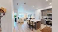 Located at 500 Baker Boulevard in Tukwila, WA, this thoughtfully designed one-bedroom, two-bathroom residence offers a modern open-concept layout that maximizes every square foot of its single-floor plan. Light wood flooring flows seamlessly throughout, creating a warm, cohesive aesthetic.

The kitchen is a standout feature, boasting sleek wood-grain cabinetry extending to the ceiling, stainless steel appliances, a white quartz countertop island with bar seating, and recessed lighting — ideal for both everyday cooking and casual entertaining. The kitchen opens directly to the living room, which is filled with natural light from a large window offering views of the surrounding neighborhood.

The living room provides a comfortable, airy atmosphere with clean white walls and ample space for relaxed living. The primary bedroom is a serene retreat, featuring a wide window, access to a dedicated closet, and light-toned walls that contribute to a bright and restful environment. Two closets offer generous storage throughout the residence.

Both bathrooms are finished in a clean, contemporary style with light wood-look flooring and tub-shower combinations. A dedicated laundry area adds everyday convenience. The overall design is clean, modern, and functional — well-suited for comfortable living in the Tukwila area.