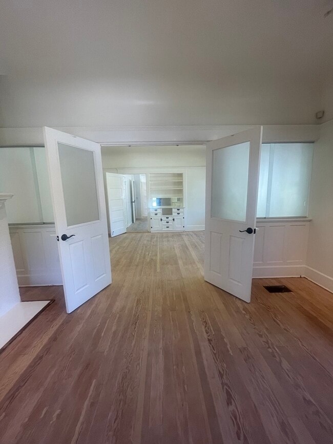 Entry doors to separate dining room with built-in cabinets. Restored hardwood floors before clear v - 1135 Magnolia St