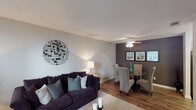 Located at 2310 W Cameo Ln in Knightdale, NC, this single-floor home offers a well-organized layout designed for comfortable everyday living. The living area greets you with neutral-toned walls, textured ceilings, and wood-style flooring at the entry that transitions into plush carpet. A large front window allows natural light to fill the space, creating a bright and welcoming atmosphere. The living area flows seamlessly into the dining space, which features a bold accent wall, ceiling fan with light fixture, and room for a full dining set. The galley-style kitchen includes white cabinetry, laminate countertops, a double-basin sink, wood-style flooring, and a deep accent wall that adds visual character. The home includes two bedrooms, each featuring soft carpet, neutral walls with dark accent walls, and natural light from windows. Both bedrooms are equipped with closets, offering practical storage. A full bathroom with a tub-shower combination and clean white surround serves the bedrooms, while a second bathroom with tile flooring, a vanity, and decorative details provides added convenience. Overall, the home presents a cohesive, neutral palette with tasteful accent walls throughout, delivering a functional and inviting single-level living experience.