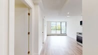 Located at 1202 Harwood Street in Vancouver's vibrant West End neighbourhood, this thoughtfully updated two-bedroom, one-bathroom unit offers a clean, modern aesthetic across its single floor. Light wood laminate flooring flows consistently throughout, creating a bright and cohesive feel in every room.

The open-concept kitchen and living area serves as the heart of the unit. The kitchen is well-appointed with white shaker-style cabinetry, a white subway tile backsplash, stainless steel appliances including a gas range, built-in microwave, dishwasher, and full-size refrigerator, complemented by matte black hardware and fixtures. Recessed lighting illuminates the space efficiently.

Both bedrooms are bright and functional, each featuring large windows that allow ample natural light and views of the surrounding cityscape. Baseboard heating runs beneath the windows, and the primary bedroom includes a mirrored sliding-door closet, offering practical storage. The second bedroom benefits from a large sliding glass door that opens to a balcony with lush tree views.

The bathroom is finished with white subway tile surrounding a full soaker tub, accented by sleek matte black fixtures, maintaining the unit's consistent modern design language throughout.