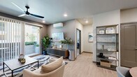 Located at 550 Marina Gateway Dr in Sparks, NV, this thoughtfully designed one-bedroom, one-bathroom residence offers a cohesive modern aesthetic across its single-floor layout. Light wood-look flooring flows throughout the open-concept living and kitchen areas, creating a bright and cohesive feel. The living room is generously proportioned, featuring a ceiling fan, a wall-mounted mini-split HVAC unit, and sliding glass doors that open to a private outdoor space, filling the room with natural light. The kitchen is well-appointed with stainless steel appliances including a French door refrigerator, a range, and a microwave, complemented by two-tone cabinetry — light wood uppers paired with white lowers — quartz countertops, and a classic subway tile backsplash. A dedicated dining area with room for a full table rounds out the space. The bedroom is carpeted and comfortably sized, offering a large window with outdoor views and access to a walk-in closet with built-in wire shelving. The bathroom includes a full soaking tub and shower combo, a wood-toned vanity with a white countertop, and built-in niche shelving. A dedicated laundry area and hallway complete this efficient and stylish home.