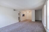 Located at 4000 Forest Creek Lane in West Deptford, NJ, this single-floor, two-bedroom, one-bathroom home offers a practical and comfortable layout. The living area is bright and open, featuring wall-to-wall carpeting and multiple tall, narrow windows that allow abundant natural light to fill the space with an airy, welcoming atmosphere.

The kitchen is efficiently designed with dark cabinetry, light stone-style countertops, stainless steel appliances including a refrigerator and electric range, a built-in microwave, and light wood-style flooring. The galley-style layout makes excellent use of the available space.

The primary bedroom is generously sized, boasting a walk-in closet with built-in shelving and two windows offering views of the surrounding greenery. The second bedroom is comfortably sized with its own pair of tall windows, plush carpeting, and a bright, neutral finish. A hallway and dedicated closet provide additional storage throughout.

The full bathroom is clean and functional, featuring a combination tub and shower, a dark wood vanity with a light countertop, wood-style flooring, and a louvered closet door for added storage. Neutral white walls and consistent finishes throughout the home create a cohesive, move-in-ready aesthetic.