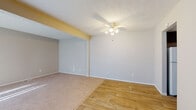 Located at 1881 Solera Dr in Columbus, Ohio, this two-floor residence offers a practical and comfortable layout designed for everyday living. The main level features a combination of wood-style flooring and plush carpeting, creating a seamless transition between the open living and dining areas. A ceiling fan with integrated lighting anchors the living space, while a textured ceiling adds subtle architectural character. Natural light filters in through vertical-blind-covered windows, brightening the generously sized living area. The kitchen is equipped with dark cabinetry, granite-style countertops, and a coil-burner electric range with an overhead ventilation hood, providing a functional cooking environment. A dedicated hallway leads to a well-appointed bathroom featuring a full tub-and-shower combination, wood-style tile flooring, and clean white fixtures. The upper level continues with soft carpeting throughout the bedrooms, each offering notable storage with dual sliding-door closets fitted with hanging rods and shelving. Additional utility is provided by a convenient half-bath or utility area on the lower level. The overall aesthetic is neutral and move-in ready, with light gray walls and white trim throughout creating a clean, cohesive look across both floors.