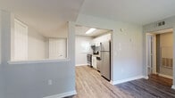 Located on Holmes St NW in Atlanta, Georgia, this single-floor residence offers a thoughtfully updated interior with a clean, modern aesthetic throughout. The open layout connects the living area to the kitchen, creating a seamless flow ideal for everyday living and entertaining.

The kitchen is a standout feature, outfitted with crisp white shaker-style cabinetry, light granite countertops, a subway tile backsplash, and a full suite of stainless steel appliances including an electric range, dishwasher, and refrigerator. A skylight overhead adds natural brightness to the space. Wood-look luxury vinyl flooring runs through the main living and kitchen areas, providing durability and a contemporary look.

The living area is generously proportioned, with neutral gray walls, clean white baseboards, and multiple windows dressed with blinds that invite natural light. Architectural details such as angled ceilings and defined entryways add character to the layout.

The bedroom features plush carpeting, soft neutral tones, and a well-sized window with views of surrounding greenery, offering a comfortable and quiet retreat. The bathroom is finished with classic white subway tile surrounding a full bathtub and shower combination, complemented by a window for natural ventilation and light. Throughout the residence, the consistent use of neutral tones and updated finishes creates a cohesive and move-in-ready environment.