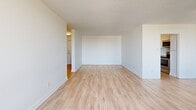 Located at 10 Highland Crescent in Kitchener, Ontario, this two-bedroom, one-bathroom unit offers a clean, functional layout with a cohesive modern aesthetic throughout. Light-toned hardwood-style flooring flows seamlessly across the living areas, bedrooms, and hallways, creating a bright and airy atmosphere. The open living room features white walls and a textured ceiling, with access to a private balcony that offers sweeping views of the surrounding Kitchener neighbourhood, including tree-lined streets and the wider cityscape. The kitchen is well-appointed with white shaker-style cabinetry, dark countertops, a classic white subway tile backsplash, and stainless steel appliances including a range and over-the-range microwave. Both bedrooms are generously sized, filled with natural light from large windows, and include baseboard heating. The primary bedroom features a set of sliding panel closet doors for ample storage. The bathroom is finished with white subway tile surrounding a full bathtub and shower, complemented by tile flooring. Additional hallways and a dedicated closet provide practical storage solutions throughout. The unit's clean, neutral palette and updated finishes make it a bright and well-organized living space.