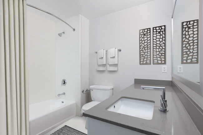 Renovated Phase I bath with quartz countertops and white cabinetry - Avalon at Mission Bay