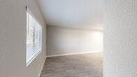 Located at 1829 E Morten Ave in Phoenix, AZ, this efficiently designed single-floor unit offers a thoughtfully organized layout that maximizes every square foot. The combined living, dining, and kitchen area forms the heart of the space, finished with wood-look luxury vinyl plank flooring in a warm gray tone that flows consistently throughout. Neutral gray walls and crisp white trim create a clean, modern aesthetic, while horizontal blinds on the windows allow for adjustable natural light.

The galley-style kitchen is a standout feature, equipped with stainless steel appliances including a refrigerator, range, and microwave. Two-tone cabinetry pairs white upper cabinets with taupe lower cabinets, complemented by white quartz countertops and a matte black single-basin sink — a cohesive and contemporary design. Overhead lighting brightens the workspace, and a pass-through opening connects the kitchen to the dining area.

The two bathrooms are finished in a light, neutral palette with updated vanities featuring gray cabinetry, white countertops, brushed nickel hardware, and a full tub-shower combination. Two dedicated closets provide practical storage solutions. The overall ambiance of the unit is bright, clean, and move-in ready, reflecting modern updates throughout.