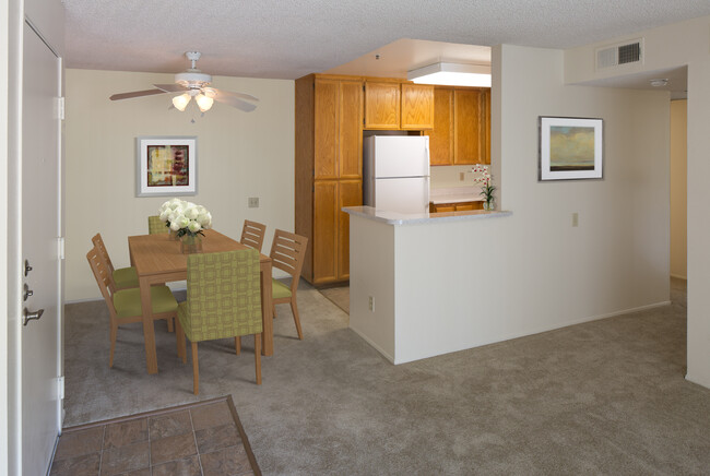 Classic Package kitchen with oak cabinetry, beige speckled laminate countertops, tile flooring, and white appliances - eaves La Mesa