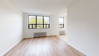 Located at 510 Dawes Rd in Toronto's east end, this one-bedroom, one-bathroom unit offers a thoughtfully laid-out single-floor plan. The living room is the heart of the space, featuring light-toned hardwood flooring, crisp white walls, and a pair of large black-framed windows that flood the room with natural light and frame views of surrounding greenery. Classic cast-iron radiators provide efficient heating throughout. The bedroom continues the same hardwood flooring and clean aesthetic, with its own black-framed window offering treetop views and a built-in closet with sliding doors for practical storage. A hallway connects the main rooms, providing a clear and functional flow through the unit. The bathroom is finished with full white square-tile surround, a soaker tub with overhead shower, a pedestal-style vanity with under-cabinet storage, and a wall-mounted mirror. Throughout the unit, the neutral white palette and consistent flooring create a cohesive, bright, and move-in-ready atmosphere. This unit is well-suited for those seeking a compact yet complete living space in a residential Toronto neighbourhood.