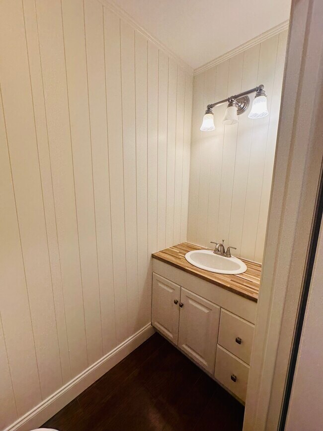 Se está añadiendo un espejo. ¿Nuevo tocador y baño con revestimiento de madera? - 703 Idlewood Ln