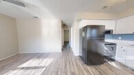 Located at 4071 76th Ave N in Pinellas Park, Florida, this two-bedroom, one-bathroom single-floor unit offers a practical and functional layout throughout. Wood-look plank flooring runs consistently across the living areas and bedrooms, providing a cohesive and clean aesthetic. Textured ceilings add character to each room.

The combined living and dining area is an open, light-filled space that connects naturally to the kitchen, which features white cabinetry, a light-toned countertop, a subway tile backsplash, and a stainless steel refrigerator. A stacked washer and dryer unit is conveniently integrated within the kitchen area, adding practical in-unit laundry access.

A hallway connects the living spaces to the two bedrooms, each brightened by windows that let in natural light and offer views of the surrounding greenery. The primary bedroom is a well-sized retreat with ample room for furnishings, while the second bedroom offers similar neutral finishes and a sliding-door closet for storage. Two closets throughout the unit provide additional organizational space.

The bathroom is clean and simply appointed, featuring a full tub-shower combination with white tile surround. Overall, the unit presents a fresh, move-in-ready feel with neutral tones and updated finishes throughout.