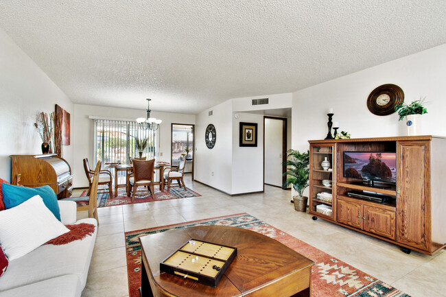 The solid wood coffee table includes lift-up eating trays for movie nights. The entertainment console is on casters so you can watch the game from the dining area if desired. - 12414 W Nugget Ct