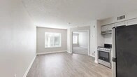 Located at 8737 Baymeadows Rd in Jacksonville, FL, this single-floor unit offers a thoughtfully designed layout with 1 bedroom and 2 bathrooms. The open living area features light-toned luxury vinyl plank flooring, neutral gray walls, and a textured ceiling, creating a clean and modern aesthetic. Natural light filters in through window blinds, enhancing the bright, airy feel of the space. The kitchen is well-equipped with gray shaker-style cabinetry, granite countertops, white subway tile backsplash, and a full suite of stainless steel appliances including a range, dishwasher, and refrigerator. The bedroom is a comfortable size, finished with plush carpet, a large window for natural light, and direct access to a private en-suite bathroom. The en-suite includes a vanity with granite countertops, gray cabinetry, a tub-shower combination with white tile surround, and wood-look tile flooring. A generous walk-in closet with built-in shelving provides ample storage. The second bathroom mirrors the clean, modern finishes found throughout the unit. Overall, the space presents a cohesive, contemporary design with quality materials and practical amenities.