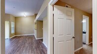 Located at 5009 Park Central Dr in Orlando, FL, this one-bedroom, one-bathroom residence offers a thoughtfully designed layout across a single floor. The open-concept living and kitchen area is anchored by rich wood-style plank flooring that flows throughout the main living spaces, complemented by vaulted ceilings that lend a sense of openness and volume. Large windows and a sliding glass door in the living room invite abundant natural light and provide access to a private balcony with greenery views, creating an airy and inviting atmosphere. A ceiling fan adds both comfort and style to the space. The kitchen is equipped with white cabinetry, dark granite-style countertops, and a stainless steel range with overhead ventilation, offering a clean and functional cooking environment. The bathroom features a wide vanity with white cabinetry, dark countertops, and a well-lit mirror. The bedroom is generously sized, finished with plush carpeting, a ceiling fan with light fixture, and a window that brings in natural light. A dedicated laundry room with a full-size washer and dryer adds everyday convenience. Warm neutral tones carry throughout, creating a cohesive and comfortable living environment.