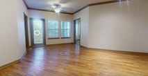 This well-designed 960 square foot apartment offers a comfortable living space with two bedrooms and two full bathrooms. The open-concept layout seamlessly integrates the kitchen and living areas, creating a spacious feel. The kitchen is equipped with modern appliances, including a refrigerator, stove, and built-in microwave, complemented by ample wood cabinetry.

The bathrooms feature dual-sink vanities with ample counter space and decorative tile accents. Both bedrooms are carpeted for comfort, with the primary bedroom measuring a generous 170 square feet. Large windows in the bedrooms and living area allow for plenty of natural light.

The apartment boasts a mix of flooring, with durable hardwood in the main living areas and kitchen, and plush carpeting in the bedrooms. Ceiling fans are installed throughout for improved air circulation. Storage is abundant, with walk-in closets in the bedrooms and additional closet space in the hallway.

The unit's neutral color palette and clean lines create a modern aesthetic, while crown molding adds a touch of elegance. The overall design prioritizes functionality and comfort, making efficient use of the 960 square foot floor plan.