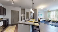 Located at 800 Milwood St in Woodstock, GA, this 2-bedroom, 3-bathroom residence offers a thoughtfully designed single-floor layout that maximizes functionality and comfort. The open-concept kitchen is a standout feature, boasting rich dark cabinetry, granite countertops, a full suite of stainless steel appliances, a tiled backsplash, and track lighting overhead. A granite-topped island with pendant lighting and bar seating flows seamlessly into the living area, making it ideal for entertaining. The living room is bright and welcoming, featuring hardwood-style flooring, a ceiling fan, large windows that invite natural light, and access to the outdoors. The spacious primary bedroom includes plush carpeting, a ceiling fan, and direct access to its own private bathroom, which features a granite vanity with dark cabinetry and a large mirror. The second bedroom is generously sized with carpet flooring and ample natural light from multiple windows. The bathrooms are well-finished, with one featuring a tiled shower-tub combination with built-in shelving. A dedicated closet provides additional storage. Neutral wall tones and consistent finishes throughout create a cohesive and modern aesthetic across the entire residence.