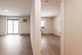 Located at 240 Prospect Ave in Hackensack, NJ, this 2-bedroom, 1-bathroom unit offers a well-organized single-floor layout with thoughtfully updated finishes throughout. The living area features wood-look laminate flooring, crisp white walls, and a textured ceiling, with a large sliding window that allows natural light to fill the space. A wall-mounted air conditioning unit and baseboard heating provide year-round climate control.

The kitchen is efficiently designed with gray shaker-style cabinetry, white countertops, a stainless steel sink, and a full suite of stainless steel appliances including a refrigerator, electric range, and dishwasher — offering both style and function in a compact galley layout.

The primary bedroom is a comfortable size, featuring the same laminate flooring and a sliding double-door closet with built-in rods and shelving for organized storage. The second bedroom is similarly appointed and benefits from natural light via its own window.

The bathroom stands out with elegant marble-style floor-to-ceiling tile, a soaking tub with overhead shower, a white vanity, and chrome fixtures, creating a clean and refined aesthetic. A hallway connects the rooms, completing this practical and attractively finished unit.