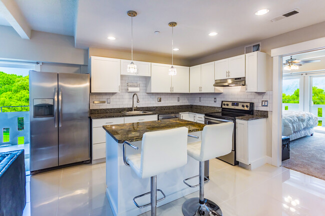 1BR, 1BA. The Kay. Kitchen and Island, Granite, Stainless Appliances, Subway Title - The Melrose Midtown