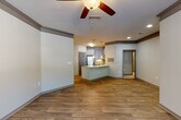 This single-floor residence offers a thoughtfully designed layout that balances comfort and functionality. The open-concept living area flows seamlessly into the kitchen, both featuring warm wood-look flooring and ceiling fans that enhance air circulation and ambiance. The kitchen stands out with gray shaker-style cabinetry, granite-look countertops, a subway tile backsplash, stainless steel appliances, and a peninsula island with pendant lighting — ideal for both everyday use and casual dining.

A welcoming entryway hallway includes a built-in countertop ledge, adding a practical touch near the entrance. The bedrooms are generously sized, with carpet flooring, ceiling fans, and windows that bring in natural light and outdoor views. Crown molding details add a refined architectural touch to select rooms.

The bathrooms are finished with white cabinetry, granite countertops, large vanity mirrors, and wood-look tile flooring. One bathroom features a soaking tub, providing a relaxing retreat. A dedicated in-unit laundry area accommodates a full-size washer and dryer side by side, with overhead shelving for added storage.

Overall, this residence presents a clean, modern aesthetic with consistent, quality finishes across every room, making it a highly functional and comfortable living space.