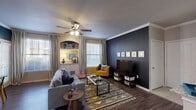 Located at 2803 Riverside Pkwy in Grand Prairie, Texas, this single-floor residence combines contemporary design with warm, inviting details throughout. The living area makes a strong visual statement with a bold dark accent wall, crown molding, and rich hardwood-style flooring. A built-in arched niche with cabinet storage and granite countertop adds architectural character, while multiple windows dressed in layered curtains and blinds allow generous natural light to fill the space. Ceiling fans are present throughout, enhancing both comfort and style.

The open-concept kitchen features stainless steel appliances, including a refrigerator, range, and microwave, complemented by granite countertops and a peninsula island with a sink — ideal for both cooking and casual interaction with the adjoining living space. The transition between tile and hardwood-style flooring cleanly delineates the kitchen from the main living area.

The bedroom is a standout space, anchored by a striking full-wall reclaimed wood panel accent that introduces rich texture and a rustic-modern aesthetic. Plush carpeting, a ceiling fan, and a bright window complete the serene retreat.

The bathroom offers a clean, functional layout with a granite-topped vanity, white cabinetry, a combination tub and shower, and hardwood-style flooring, rounding out this well-designed home.