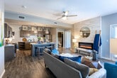 This single-floor residence in Lubbock, TX offers a thoughtfully designed layout that blends modern finishes with comfortable living. The open-concept kitchen is a standout feature, boasting rich dark-toned cabinetry, granite countertops, a herringbone tile backsplash, stainless steel appliances, and a central island with bar seating illuminated by geometric pendant lighting — ideal for casual dining and entertaining. Wood-look plank flooring flows seamlessly through the main living areas, adding warmth and cohesion to the space. The living room is anchored by a sleek linear fireplace set against a textured stone accent wall, with large windows that invite natural light and a ceiling fan overhead. Two well-sized bedrooms feature plush carpeting, ceiling fans, and generously sized windows with views of the outdoors. Both bathrooms are finished with granite vanity countertops, dark cabinetry with ample storage, and tub-shower combinations. The overall design palette — cool grays, warm wood tones, and crisp whites — creates a clean, contemporary ambiance throughout the home, making it a functional and stylish living space in the heart of Lubbock.