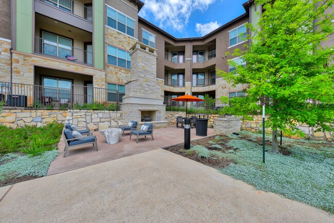 Poolside Stone Fireplace with Cozy Seating and Grilling Area - Bexley Wolf Ranch