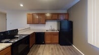 Located at 6101 Vine St in Lincoln, Nebraska, this single-floor unit offers a practical and comfortable layout designed for everyday living. The open living area features neutral-toned carpeting, a ceiling fan with light fixture, and vertical blinds that allow natural light to filter in, creating a bright and inviting atmosphere. A transition to wood-look vinyl flooring marks the entry into the kitchen and dining area.

The kitchen is well-appointed with warm wood-toned cabinetry extending to the ceiling for generous storage, light granite-style countertops, a tile backsplash, and a full suite of black appliances including a range, dishwasher, and refrigerator. A double-basin sink with a window-adjacent position completes the functional workspace.

The bedroom is spacious with soft carpeting underfoot, vertical blinds along a wide window wall, and an impressive built-in closet system featuring shelving, hanging rods, and additional shelving units — offering exceptional organizational capacity.

The bathroom includes a full-size soaking tub and shower combination with clean white tile surround, providing a classic and easy-to-maintain bathing space.

Throughout the unit, clean white walls, consistent flooring choices, and ceiling fans contribute to a cohesive, low-maintenance living environment well-suited for comfortable day-to-day use.