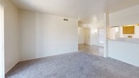 Located at 5301 Marvin D Love Fwy in Dallas, TX, this single-story, 2-bedroom, 2-bathroom unit offers a practical and comfortable layout. The entrance opens into a hardwood-style flooring area that flows into a carpeted living room, which features built-in shelving and a sliding glass door fitted with vertical blinds, allowing natural light to filter through. An adjacent dining area connects seamlessly to the galley-style kitchen, which is equipped with warm wood cabinetry, light countertops, a double-basin sink, and white appliances including a range and refrigerator. A window above the kitchen sink provides additional natural light. The primary bedroom is a well-proportioned retreat with carpet flooring, a walk-in closet outfitted with built-in shelving, and a dedicated built-in desk area. The second bedroom also features carpet flooring and a window with exterior views. Four closets throughout the unit offer generous storage. The two bathrooms include wood-toned cabinetry, overhead lighting, and hardwood-style flooring. Neutral wall tones and clean finishes give the space a bright, move-in-ready appeal throughout.