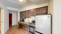 Located in Detroit's vibrant Midtown neighborhood, this one-bedroom, one-bathroom unit offers a practical and well-organized layout across a single floor. The entrance leads into a light-filled living room featuring neutral tile flooring, crisp white walls, and a large window that invites natural light and views of the surrounding cityscape. A wall-mounted HVAC unit ensures year-round comfort.

The kitchen is efficiently designed with rich dark-wood cabinetry extending to the ceiling for ample storage, granite-style countertops, a subway tile backsplash, and a full suite of appliances including an electric range, refrigerator, and built-in microwave. Tile flooring completes the clean, functional aesthetic.

The bedroom is a calm, sunlit retreat with a window fitted with blinds, neutral flooring, and access to a closet. A second closet provides additional storage within the unit.

The bathroom is thoughtfully appointed with accessibility features including grab bars, a floating dark-wood vanity with a granite countertop, a large mirror, a medicine cabinet, and tile flooring. The layout accommodates ease of movement throughout.

Overall, this unit presents a clean, functional living space well-suited for those seeking a compact yet complete home in the heart of Detroit.