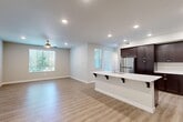 Located at 2740 E Shepherd Ave in Fresno, CA, this single-story, 4-bedroom, 3-bathroom home offers a well-designed open-concept layout. The combined kitchen and living area serves as the heart of the home, featuring light wood-look flooring, recessed lighting, and a ceiling fan. The kitchen is equipped with rich dark-espresso cabinetry extending to the ceiling, crisp white countertops, stainless steel appliances including a gas range, microwave, and refrigerator, and a central island with bar seating — ideal for both cooking and casual dining. Large windows throughout the living area allow natural light to pour in, creating a bright and welcoming atmosphere. The four bedrooms are carpeted for comfort, with the primary bedroom offering wood-look flooring, a ceiling fan, and a generously sized window with outdoor views. Bedrooms include sliding-door closets, while additional walk-in closet storage features built-in shelving and hanging rods. The three bathrooms maintain a consistent design language, with dark wood vanities, white countertops, large mirrors, and light wood-look flooring. The hallway connects the private quarters smoothly. Neutral tones and clean finishes throughout give the home a modern, move-in-ready feel.