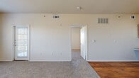 Located in San Antonio, TX, this one-bedroom, one-bathroom unit offers a practical and well-organized single-floor layout. The open living area features neutral-toned carpet, a ceiling fan, and a large window alongside a glass-panel door that leads out to a private balcony, filling the space with natural light and outdoor views. The kitchen is equipped with warm hardwood flooring, ample white cabinetry with wood trim, a double sink, dishwasher, and a white range — providing all the essentials for everyday cooking. The bedroom is a comfortable, carpeted retreat featuring two windows that invite natural light and greenery views, along with a ceiling fan for added comfort. The full bathroom includes a wide vanity with wood-accented cabinetry, a large mirror, tiled shower/tub combo, and direct access to a walk-in closet with built-in shelving. A second closet provides additional storage. An in-unit laundry area adds convenience to daily routines. Throughout the unit, a consistent neutral color palette, clean white trim, and a mix of hardwood and carpet flooring create a cohesive and functional living environment.
