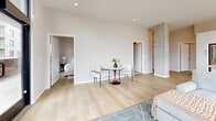 Located in the heart of Denver's Golden Triangle neighborhood, this modern 2-bedroom, 2-bathroom residence offers a sleek, contemporary design with high-end finishes throughout. The open-concept kitchen and living area is a standout feature, anchored by large floor-to-ceiling windows that flood the space with natural light and frame sweeping city views. The kitchen is outfitted with white cabinetry, quartz countertops, stainless steel appliances, a gas range, and a center island with bar seating, all complemented by warm pendant lighting and exposed concrete columns that add an industrial touch. Light wood flooring flows seamlessly through the living and dining areas, enhancing the bright, airy atmosphere. The primary bedroom is generously sized, offering direct access to a sprawling private outdoor terrace with panoramic city views, while a second bedroom features its own large window with urban views and a built-in closet. Both bathrooms are finished in a clean, minimalist style — the primary bath features a floating double vanity with quartz countertops and matte black hardware, while the second bath includes a tiled soaking tub and shower combination. Recessed lighting and neutral tones throughout the space contribute to a polished, cohesive aesthetic ideal for modern urban living.