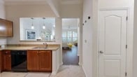 Located at 2373 SW Archer Rd in Gainesville, FL, this well-appointed 2-bedroom, 2-bathroom single-floor residence offers a thoughtful layout designed for comfortable everyday living. The inviting living room is a standout feature, boasting soaring ceilings, crown molding, a ceiling fan, and a striking set of arched windows that flood the space with natural light and views of the surrounding greenery. Rich hardwood-style flooring runs throughout the main living areas, adding warmth and continuity.

The kitchen is well-equipped with warm-toned cabinetry, granite countertops, black appliances, a tile backsplash, and a double-basin sink set into a peninsula that opens to the dining area via a pass-through, enhanced by stylish pendant lighting. The primary bedroom is generously sized with high ceilings, hardwood-style flooring, and access to a spacious walk-in closet with wire shelving. The second bedroom is bright and welcoming, featuring large windows with outdoor views. Both bathrooms are finished with granite vanities and matching cabinetry. A dedicated in-unit laundry room with a full-size washer and dryer adds everyday convenience, rounding out this functional and attractive Gainesville home.