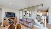 Located at 6806 E County Line Rd in Indianapolis, IN, this single-floor community space offers a well-designed layout that seamlessly blends comfort and functionality. The living room is a welcoming area highlighted by light hardwood flooring, a textured ceiling, and a sage-green accent wall adorned with contemporary artwork. A built-in electric fireplace anchors a warm, relaxed seating arrangement, while large windows and a glass door invite abundant natural light and outdoor views. A staircase with modern black iron balusters adds a refined architectural touch to the space. The open kitchen is outfitted with white cabinetry, granite countertops, a subway tile backsplash, and stainless steel appliances, creating a clean and practical workspace. A window above the sink provides views to the exterior, enhancing the bright, airy atmosphere. The expansive dining room is the standout feature of this space, configured to accommodate large groups with long communal tables and numerous chairs. A dark accent wall, wall-mounted television, fireplace, and recessed lighting contribute to a polished, professional ambiance, making it well-suited for meetings, events, or gatherings. Throughout the space, consistent light hardwood flooring and neutral tones create a cohesive and inviting environment.