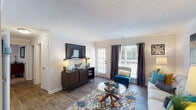 Located at River Pointe Place in High Point, North Carolina, this single-story residence offers a well-organized layout across multiple rooms, each finished with consistent, functional details. The living room features wood-style flooring, crown molding, and a textured ceiling, with natural light entering through a set of plantation-shuttered windows and a glass door. The space accommodates comfortable seating arrangements and includes wall-mounted display areas.

Adjacent to the living room, the dining area is defined by chair-rail molding, wood-style flooring, and overhead lighting, with direct sightlines into the kitchen. The kitchen is equipped with dark cabinetry, light granite-style countertops, stainless steel appliances including a refrigerator, dishwasher, and microwave, as well as a double-basin sink.

The residence includes two bedrooms, each carpeted and fitted with ceiling fans and windows that bring in natural light. Both rooms offer closet access and a quiet, restful atmosphere. Two full bathrooms serve the unit, each featuring a tub-shower combination with chrome fixtures, a vanity, and wood-style flooring. Textured ceilings are consistent throughout the home, contributing to a cohesive interior character.