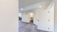 Located at 1707 Element Lane in Sandpoint, Idaho, this one-bedroom, one-bathroom unit offers a clean, modern design with a practical and well-organized floor plan. Wood-style plank flooring runs throughout the entire space, providing a cohesive and contemporary look.

The open-concept kitchen and living area forms the heart of the unit. The kitchen is well-appointed with light wood cabinetry featuring sleek black hardware, dark granite-style countertops, and a full suite of stainless steel appliances including a range, dishwasher, refrigerator, and microwave. Recessed lighting illuminates the space, and a window above the sink brings in natural light. A sliding glass door in the living area provides additional natural light and outdoor access.

The living room offers a comfortable, open layout with clean white walls and recessed lighting. The bedroom is a well-sized private retreat featuring multiple windows with blinds, a wall-mounted HVAC unit, and ample natural light.

The bathroom is thoughtfully designed with a light wood vanity, dark countertop, a large mirror with modern lighting, and accessibility features including grab bars near the toilet and shower. A small window provides ventilation and natural light. The unit's overall aesthetic is bright, clean, and move-in ready.