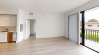 This thoughtfully designed single-story residence offers three bedrooms and two bathrooms across a well-organized floor plan. A consistent palette of crisp white walls and light wood-tone flooring flows throughout every room, creating a clean, cohesive aesthetic.

The kitchen is a standout feature, outfitted with floor-to-ceiling light wood cabinetry, white quartz countertops, and a full suite of stainless steel appliances including a range, microwave, dishwasher, and a side-by-side refrigerator. Ample upper and lower cabinet storage makes this space as functional as it is modern.

The primary bedroom is a comfortable retreat with direct access to its dedicated bathroom, which features a sleek floating vanity with an undermount sink, a glass-enclosed tiled shower, and a tall storage tower. The second bathroom is equally well-appointed, featuring a streamlined vanity and mirror.

The additional bedrooms are bright and versatile — one enjoys a window with outdoor views and natural light, while another benefits from sliding panel doors. A stacked in-unit washer and dryer is conveniently tucked within the layout. Two closets provide additional storage. The overall ambiance is contemporary and minimalist, offering a clean, move-in-ready environment.