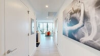 Located at 700 Northeast 1st Avenue in the heart of downtown Miami, this thoughtfully designed one-bedroom, one-bathroom residence delivers a refined urban living experience. Light-toned large-format tile flooring flows throughout, anchoring a clean, modern aesthetic defined by crisp white walls and recessed lighting.

A welcoming entry corridor leads into the open-concept living area, where floor-to-ceiling windows and a glass-panel balcony door frame sweeping, elevated views of the Miami skyline. The living room offers generous space for seating and entertainment, while the adjacent dining area and kitchen form a cohesive, functional hub. The kitchen features stainless steel appliances, a peninsula with bar seating, pendant lighting, and ample cabinetry.

The primary bedroom benefits from expansive windows that continue the panoramic city views, providing an abundance of natural light. A dedicated walk-in closet with built-in shelving and hanging rods offers well-organized storage.

The bathroom is finished to a high standard, featuring a glass-enclosed walk-in shower, a floating vanity with an illuminated mirror, and light wood-tone tile flooring that complements the rest of the residence. This well-appointed home combines contemporary design with a prime Miami location.