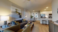 This thoughtfully designed single-floor residence offers a seamless open-concept layout that connects the living, dining, and kitchen areas into one cohesive, light-filled space. The living area features warm hardwood-style flooring, a ceiling fan, and bold abstract wall art, creating an inviting atmosphere. Large French doors flood the space with natural light and provide outdoor views, while the adjacent dining area offers a comfortable setting for everyday meals.

The kitchen is outfitted with crisp white shaker cabinetry, granite countertops, a subway tile backsplash, and a full suite of stainless steel appliances, including a refrigerator with an in-door dispenser, electric range, and over-the-range microwave. A breakfast bar adds casual dining functionality.

The primary bedroom is generously sized with hardwood-style flooring, a ceiling fan, and an en-suite bathroom featuring a combination tub and shower. A secondary bedroom provides ample natural light through large windows and is serviced by a dedicated bathroom with granite countertops and a glass-enclosed walk-in shower. Additional highlights include a dedicated in-unit laundry closet, a smart thermostat, and a neutral, warm-toned color palette throughout that lends the space a modern yet comfortable character.
