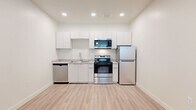 Located at 5900 N 99th Ave in Phoenix, Arizona, this 2-bedroom, 1-bathroom residence offers a thoughtfully designed single-floor layout with a clean, modern aesthetic. The open-concept kitchen and living area is bright and functional, featuring sleek white cabinetry, stainless steel appliances including a range, microwave, refrigerator, and dishwasher, and light-toned laminate flooring that flows seamlessly throughout the common areas. Recessed lighting illuminates the space, creating a fresh and welcoming atmosphere. The living area provides a comfortable, versatile space suited to a variety of arrangements. Both bedrooms are carpeted for warmth and comfort, each featuring natural light through blinded windows. The bedrooms are served by two closets for ample storage. Each bedroom also includes its own wall-mounted mini-split system for individual climate control, with ceiling fans adding to overall comfort. The shared bathroom is clean and well-appointed, offering a full soaking tub and shower combo, a vanity with stone-look countertops, and light wood-style flooring. The overall design is minimal and neutral, providing a versatile canvas throughout this efficiently designed Phoenix residence.