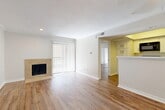 Located at 9600 Golf Lakes Trail in Dallas, TX, this one-bedroom, two-bathroom residence offers a well-designed, single-floor layout that makes efficient use of its space. Warm wood-look flooring flows throughout, creating a cohesive and inviting atmosphere across all rooms.

The living room serves as the heart of the home, anchored by a tile-surround fireplace and a sliding glass door with vertical blinds that allows generous natural light to fill the space. Crown molding adds a refined finishing touch. Adjacent to the living area, a dedicated dining space connects seamlessly to the kitchen.

The kitchen is well-appointed with white shaker-style cabinetry, quartz countertops, a subway tile backsplash, and a full suite of black appliances including a range, over-the-range microwave, dishwasher, and stainless steel refrigerator. A peninsula with a sink provides additional prep space and opens toward the dining area. A pantry and in-unit laundry area are conveniently tucked nearby.

The bedroom is comfortably sized, featuring a ceiling fan, a sliding glass door for natural light, and a mirrored closet. The en-suite bathroom includes white cabinetry with quartz countertops, a large vanity mirror, and direct access to the closet area. A second full bathroom serves guests. Two closets provide ample storage throughout the home.
