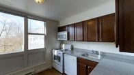 Located at 27 Claremont Gardens in Ossining, NY, this two-floor residence offers four bedrooms and one and a half bathrooms, providing ample space for comfortable living. The home is thoughtfully laid out across two levels, allowing for a natural separation between living and sleeping areas.

The kitchen is a functional and well-appointed space featuring rich, dark-stained wood cabinetry that provides generous storage both above and below the countertops. Granite-look countertops complement the cabinetry and offer solid prep space. White appliances — including a gas range, dishwasher, and built-in microwave — keep the kitchen practical and easy to use. A stainless steel sink sits beneath a large window that brings in natural light and offers views of the surrounding neighborhood. Crown molding along the ceiling adds a clean, finished detail to the space, while the hardwood flooring grounds the room with warmth and durability.

With four bedrooms spread across two floors, the home offers flexibility for families, guests, or dedicated work-from-home spaces. The 1.5 bathrooms provide convenience for everyday living. Situated in Ossining, NY, residents benefit from a well-established community with access to local amenities, schools, and transit options.