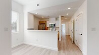 Located in Austin's vibrant 78702 zip code, this thoughtfully designed one-bedroom, one-and-a-half-bathroom residence makes efficient use of its single-floor layout with clean, modern finishes throughout. Light wood-look flooring flows seamlessly across every room, lending a bright and cohesive aesthetic.

The open-concept kitchen is a standout feature, offering a peninsula with white quartz countertops, warm wood cabinetry with matte black hardware, a sleek black undermount sink, and a full suite of stainless steel appliances including a gas range, microwave, and refrigerator. A subway tile backsplash and a window above the sink add both style and natural light to the space.

A central hallway connects the living area to the private quarters, with a stylish sliding barn door adding a modern-rustic touch. The bedroom is generously proportioned for the overall footprint, featuring two closets with panel doors, a window with blinds, and a tray ceiling detail that adds architectural interest.

The full bathroom is finished with large-format stone-look wall tile, a soaking tub with an integrated rain shower system, and warm wood vanity cabinetry paired with white countertops. The half bath provides added convenience for guests. Recessed lighting throughout ensures consistent, well-distributed illumination across the entire unit.