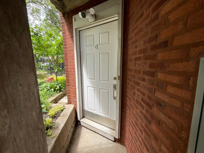 exterior covered front door with security camera looking at mail boxes - 2422 W Thomas St